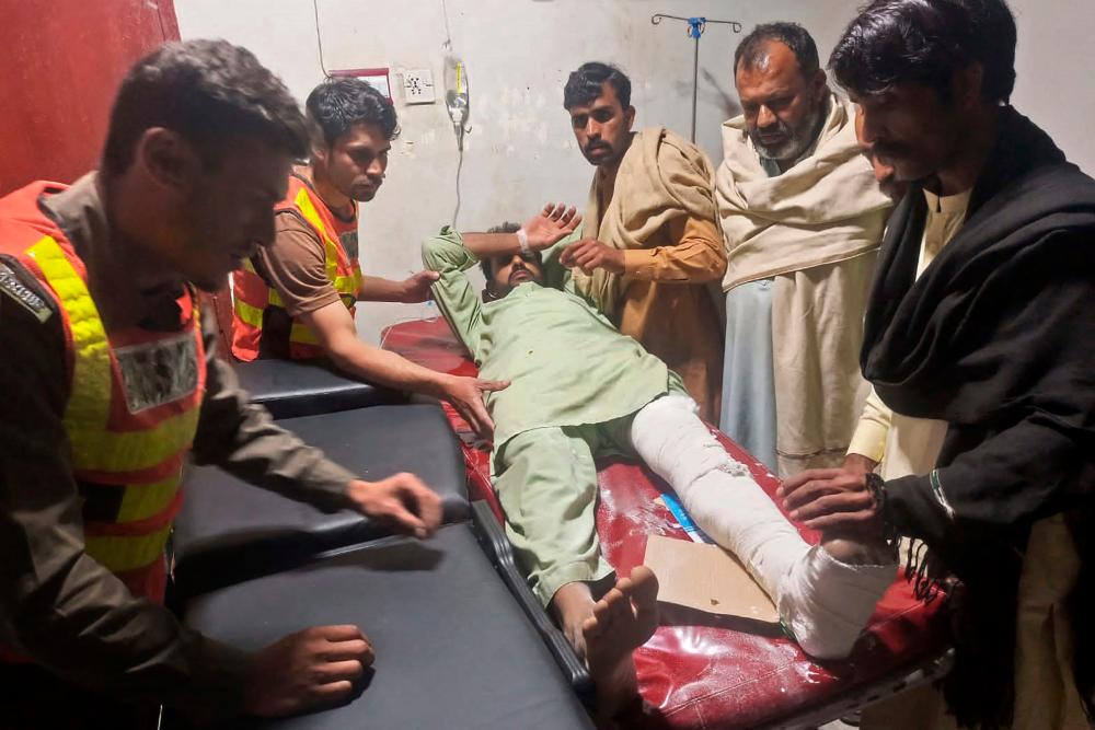 This handout photograph released by the Pakistan’s Emergency Rescue 1122 Service on March 22, 2023 shows rescue workers attending an earthquake victim at a hospital in Swat of Khyber Pakhtunkhwa province. AFPPIX