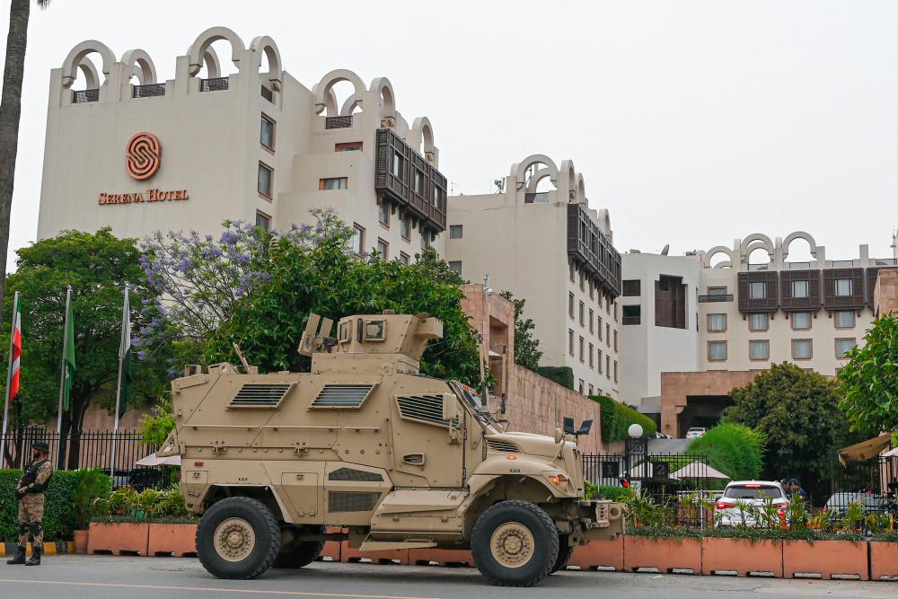 A security personnel (L) stands guard next to an armoured vehicle in front of a hotel in Islamabad on May 5, 2023, as security tightens in Pakistan’s capital ahead of the foreign ministers meeting of Pakistan, China and Afghanistan. AFPPIX