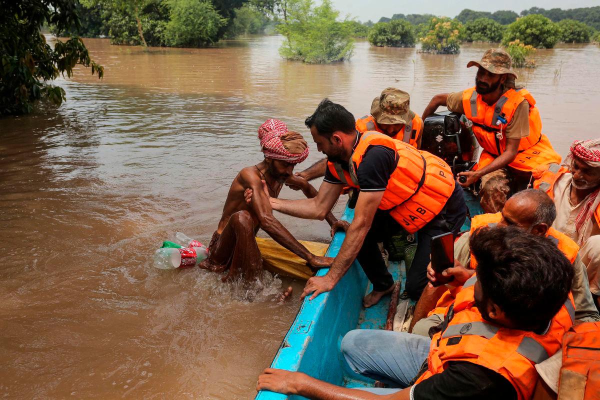 A rescuer pulls a flood-affected man on board a boat after the flood in the Chenab river, in Muzaffargarh in Punjab province on September 6, 2025. Water has gushed into the eastern province, Pakistan’s breadbasket and home to about half of its 255 million people, with three transboundary rivers swelling beyond their banks. (Photo by Shahid Saeed MIRZA / AFP)
