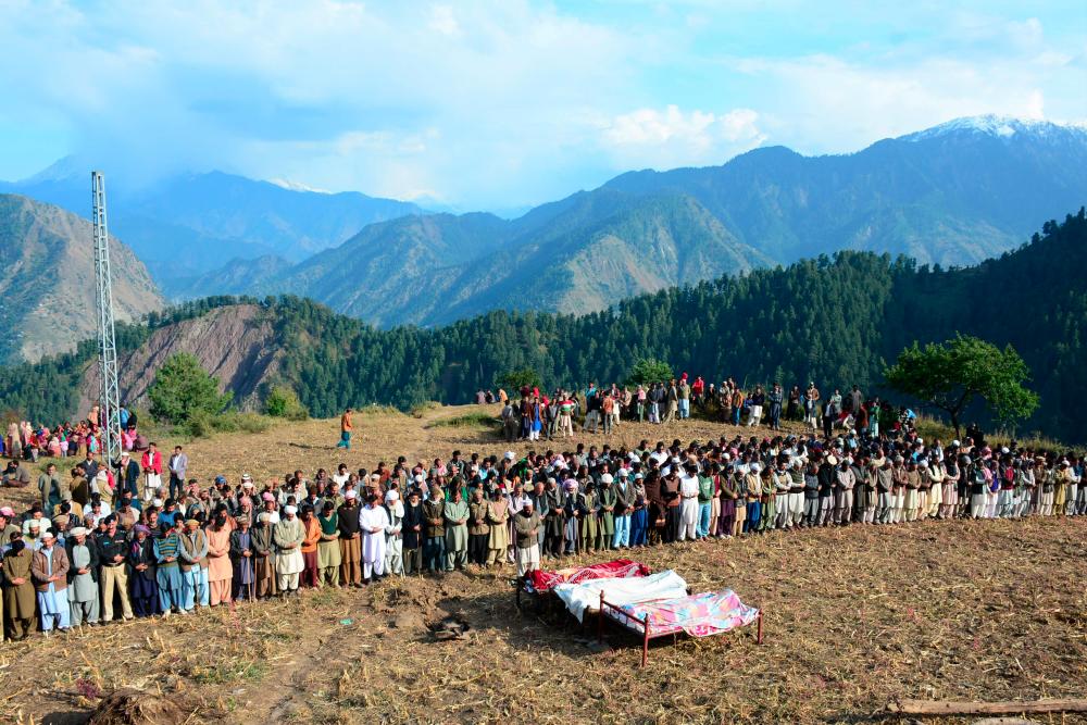 People gather during funeral prayer for victims of cross border shelling in Nosari sector in Pakistan-administered Kashmir on Oct 20, 2019. — AFP