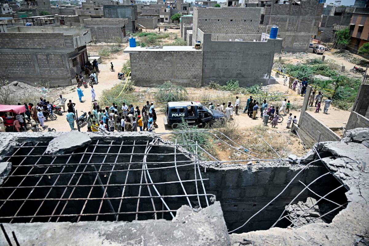 Residents gather as police personnel inspect the site where an alleged drone was shot down in Karachi on May 8, 2025. Pakistan’s army said on May 8, it shot down 25 Indian drones, a day after the worst violence between the nuclear-armed rivals in two decades. AFPpix