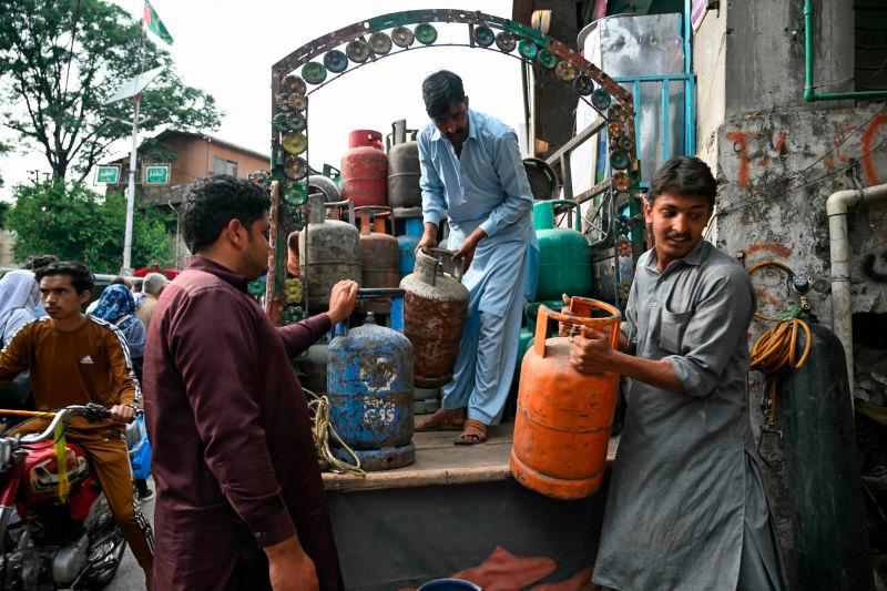 Shopkeepers unload gas cylinders at a market in Muzaffarabad on May 2, 2025. AFPpix