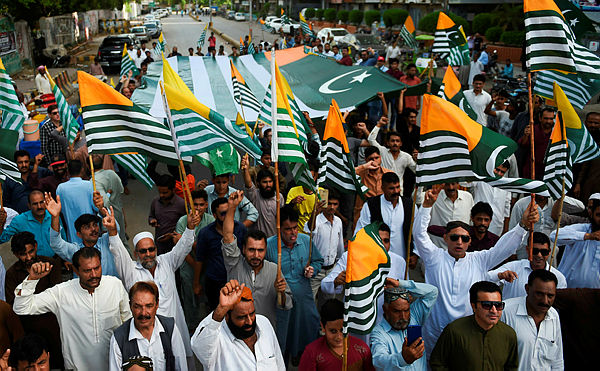 Pakistanis demonstrators carry flags of Pakistan-administered Kashmir during an anti-Indian protest in Karachi on August 18, 2019. — AFP