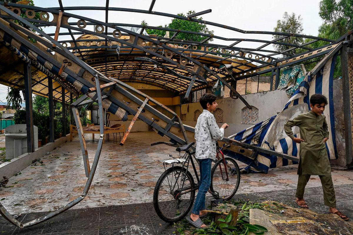 Youths gather in front of the wreckage of a restaurant’s shade outside the Rawalpindi cricket stadium after an alleged drone was shot down in Rawalpindi on May 8, 2025. AFPpix