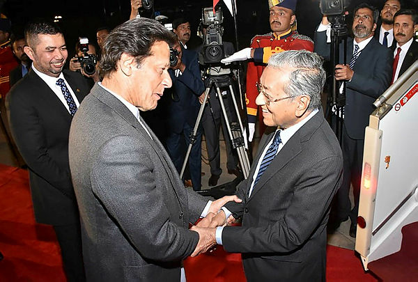 In this handout picture released by Pakistan Press Information Department (PID) on March 21, 2019, Pakistani Prime Minister Imran Khan (L) receives Prime Minister Tun Dr Mahathir Mohamad on his arrival in Islamabad. — AFP