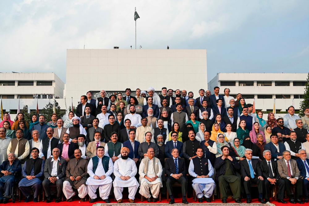 Pakistan’s Prime Minister Shehbaz Sharif (7R in front row) poses for a group photograph with parliamentarians of the National Assembly outside the parliament house building in Islamabad on August 9, 2023. AFPPIX