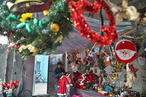In this picture taken on Dec 12, 2018, Christmas decoration seller Amjab Burgkat tidies his shop in 100 Quarters Colony, one of Islamabad’s impoverished Christian ghettos. — AFP
