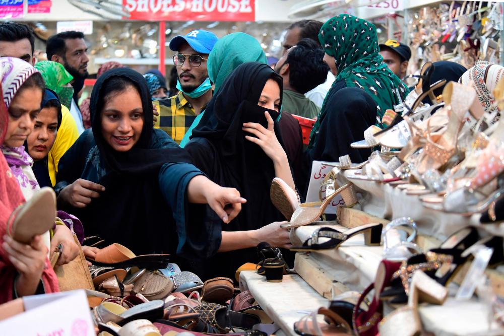 Women look at shoes at market during shopping ahead of the upcoming festival of Eid al-Fitr in Karachi on April 19, 2023. AFPPIX