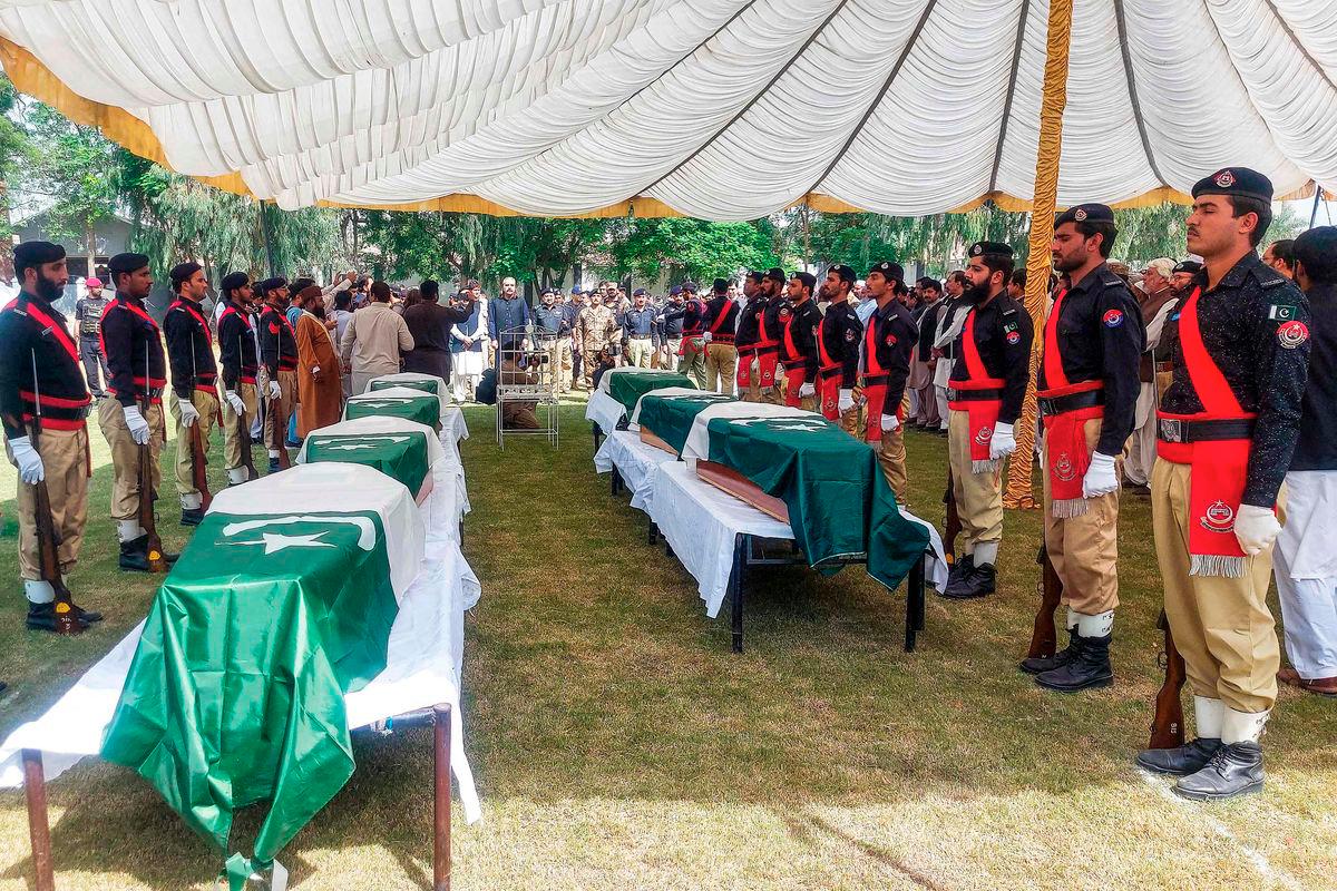 Policemen stand by the coffins of slain police personnel during a funeral ceremony at Dera Ismail Khan in Khyber Pakhtunkhwa province on October 11, 2025, a day after they were killed in a suicide bombing attack at a police training school. The Pakistani Taliban on October 11, claimed responsibility for deadly attacks in several northwestern districts that killed 20 security officials and three civilians. - AFP