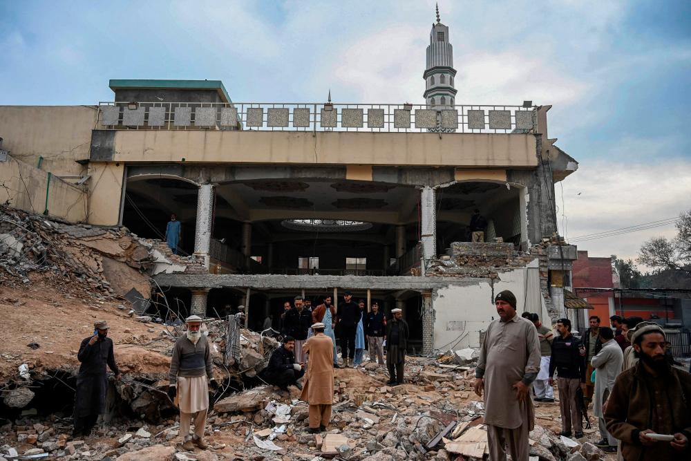 Plain-clothed policemen inspect the site as they gather over the rubble of a damaged mosque following January’s 30 suicide blast inside the police headquarters in Peshawar on February 1, 2023. AFPPIX