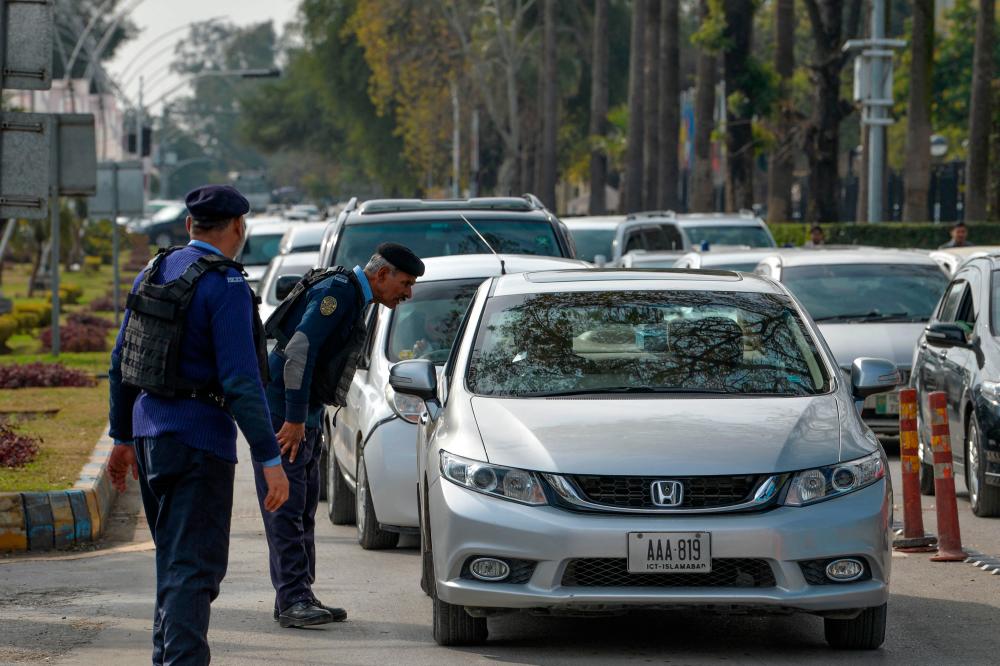 A policeman speaks to a commuter at a checkpoint outside the constitution avenue in Islamabad on January 31, 2023. AFPPIX