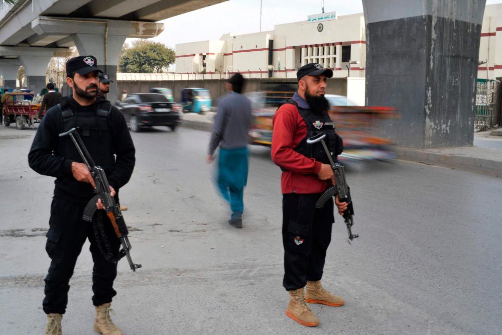 Policemen stand guard along a street in Peshawar on February 1, 2023, days after a mosque suicide blast inside a police headquarters. AFPPIX