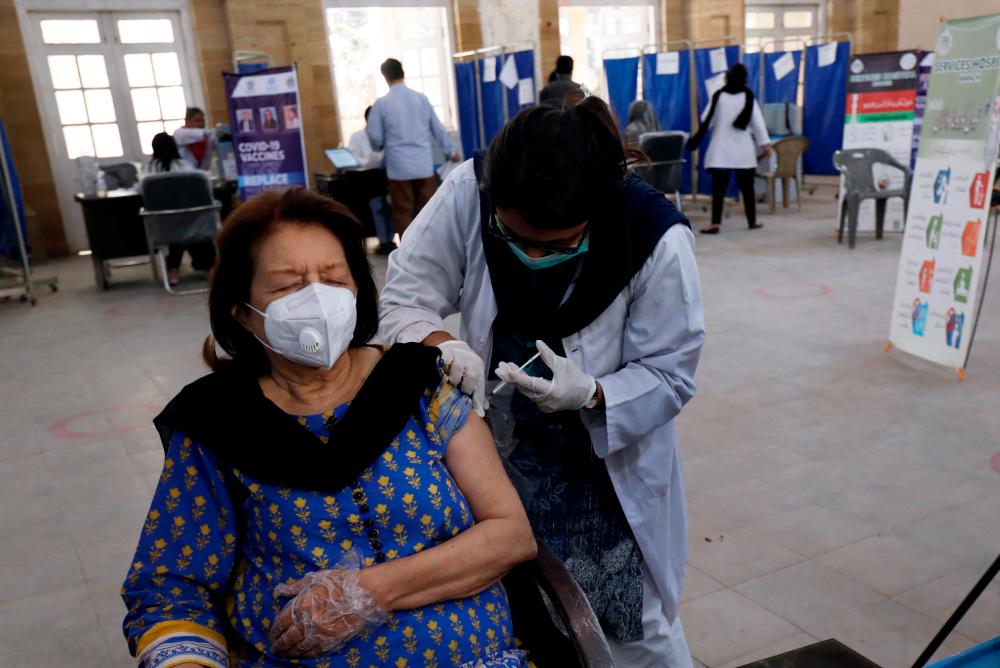 A woman receives the first dose of the coronavirus disease (Covid-19) vaccine, as the government started vaccination for the general public, starting with elderly people, at a vaccination center in Karachi, Pakistan March 10, 2021. — Reuters