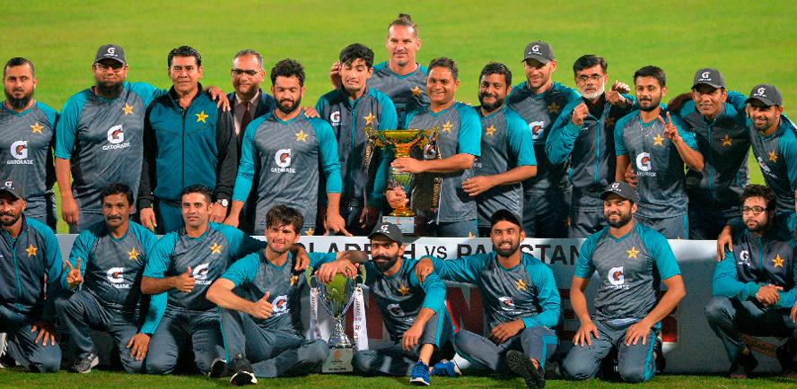 Pakistan’s cricketers pose for pictures with the trophy after winning the final day play of the second Test cricket match against Bangladesh at the Sher-e-Bangla National Cricket Stadium in Dhaka on Dec 8, 2021. – AFPPIX