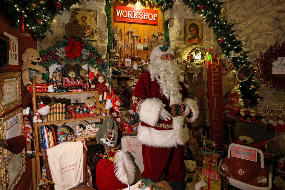 Palestinian Issa Kassissieh, dressed as Santa Claus, poses for a picture at a floor of his home which he turned into Santa’s House, in Jerusalem’s Old City, a few weeks before the upcoming holiday of Christmas, on November 30, 2022/AFPPix