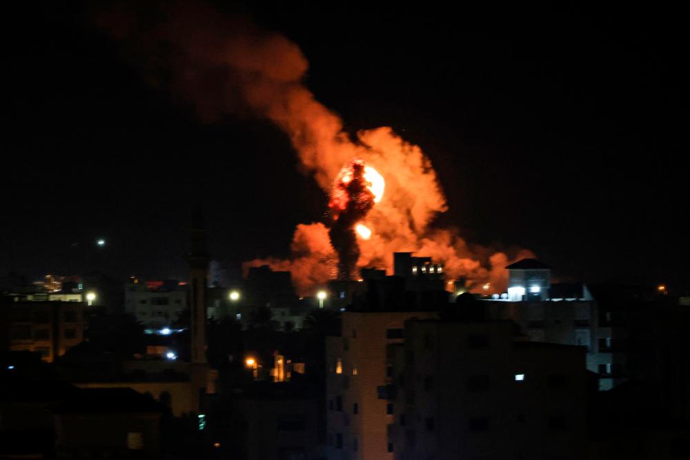 Fire and smoke rise above buildings in Gaza City as Israel launched air strikes on the Palestinian enclave early on February 13, 2023/AFPPix