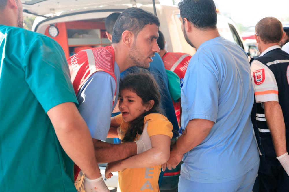 EDITORS NOTE: Graphic content / Rescuers bring a Palestinian girl to a hospital following an Israeli strike, in Khan Yunis in the southern Gaza Stripon October 14, 2023, as fighting between Israel and the Hamas movement continues for the eigth consecutive day. - AFPPIX