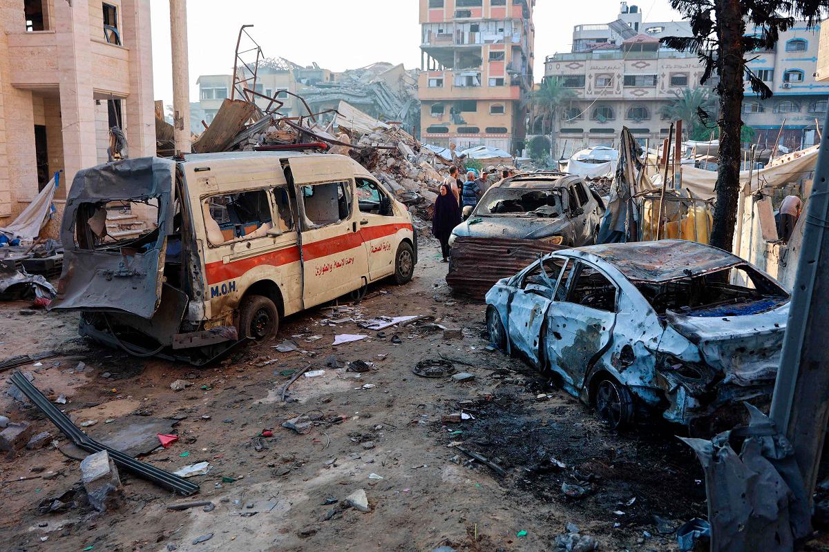 Palestinians inspect the damage, including a destroyed ambulance, around a house hit in an Israeli strike a day earlier in western Beit Lahia in the northern Gaza Strip on July 23, 2025. - Omar AL-QATTAA / AFP