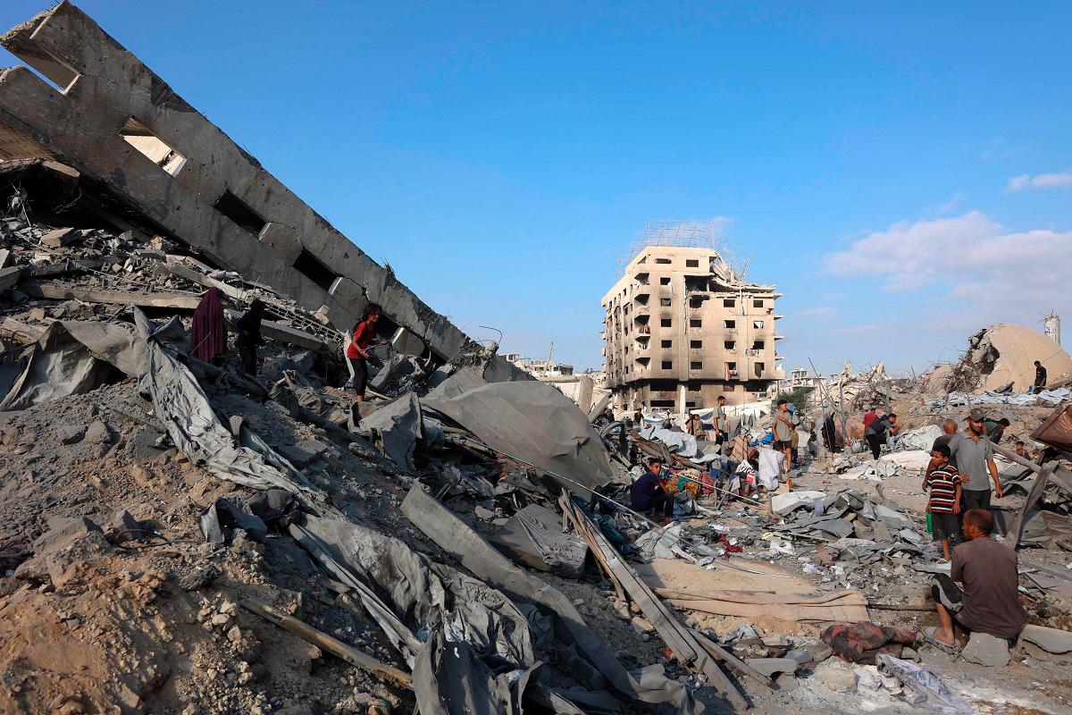 Palestinians inspect the damage after an overnight strike on the Sheikh Radwan Health Centre in the north of Gaza City on August 6, 2025. Gaza’s civil defence agency said 68 people were killed by Israeli gunfire and air strikes on August 5, including 56 who were waiting near aid distribution sites inside the Palestinian territory. - Omar AL-QATTAA / AFP