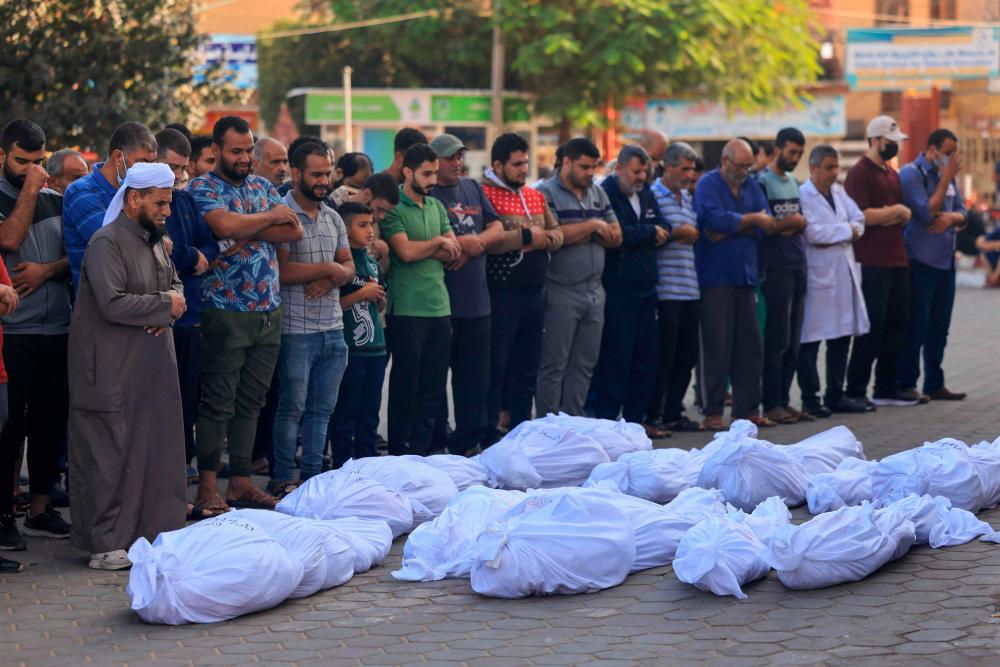 Palestinians pray by the bodies of relatives killed following Israeli bombardment, at Al-Aqsa hospital in Deir Al-Balah in the central Gaza Strip on November 1, 2023, amid ongoing battles between Israel and the Palestinian Hamas movement/AFPPix
