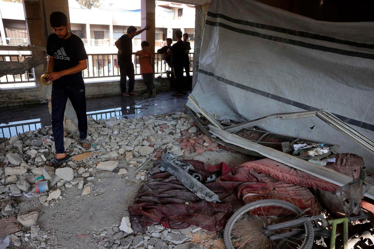 Displaced Palestinians check the destruction in a classroom used as a temporary shelter, inside a school hit by an Israeli strike in the Al-Iskandar neighbourhood, north of Gaza City on June 26, 2025. (Photo by BASHAR TALEB / AFP)