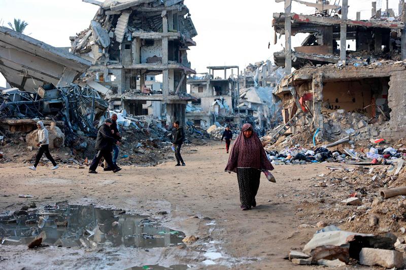 Graphic content / Palestinians walks amid the destruction in the Shujaiya neighbourhood of Gaza City, in the northern Gaza Strip on January 4, 2025, as the war between Israel and Hamas militants continues. -Omar AL-QATTAA / AFP