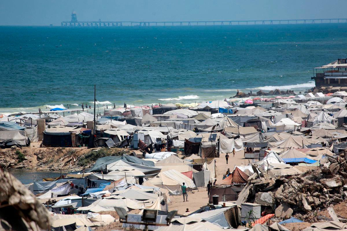 Tents used as temporary shelters by displaced Palestinians are set up around war-damaged structures along the beach in Gaza City on August 8, 2025. AFP