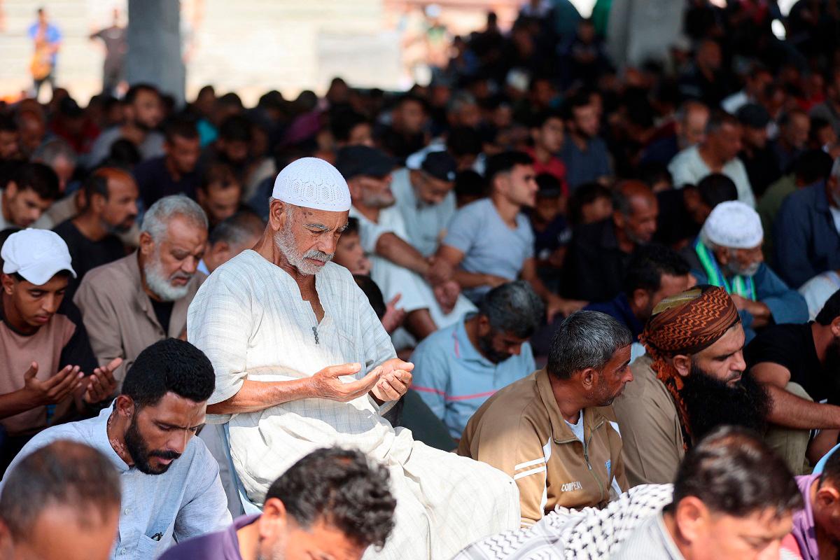 Palestinian Muslim worshippers attend friday prayers amidst the rubble of the destroyed Albaani Mosque in Khan Yunis in the southern Gaza Strip on October 17, 2025. - AL-QATTAA / AFP