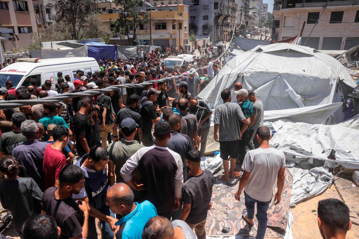 People check the site on an Israeli strike next to a tent housing displaced Palestinians, in Gaza City, on July 8, 2025. (Photo by BASHAR TALEB / AFP)