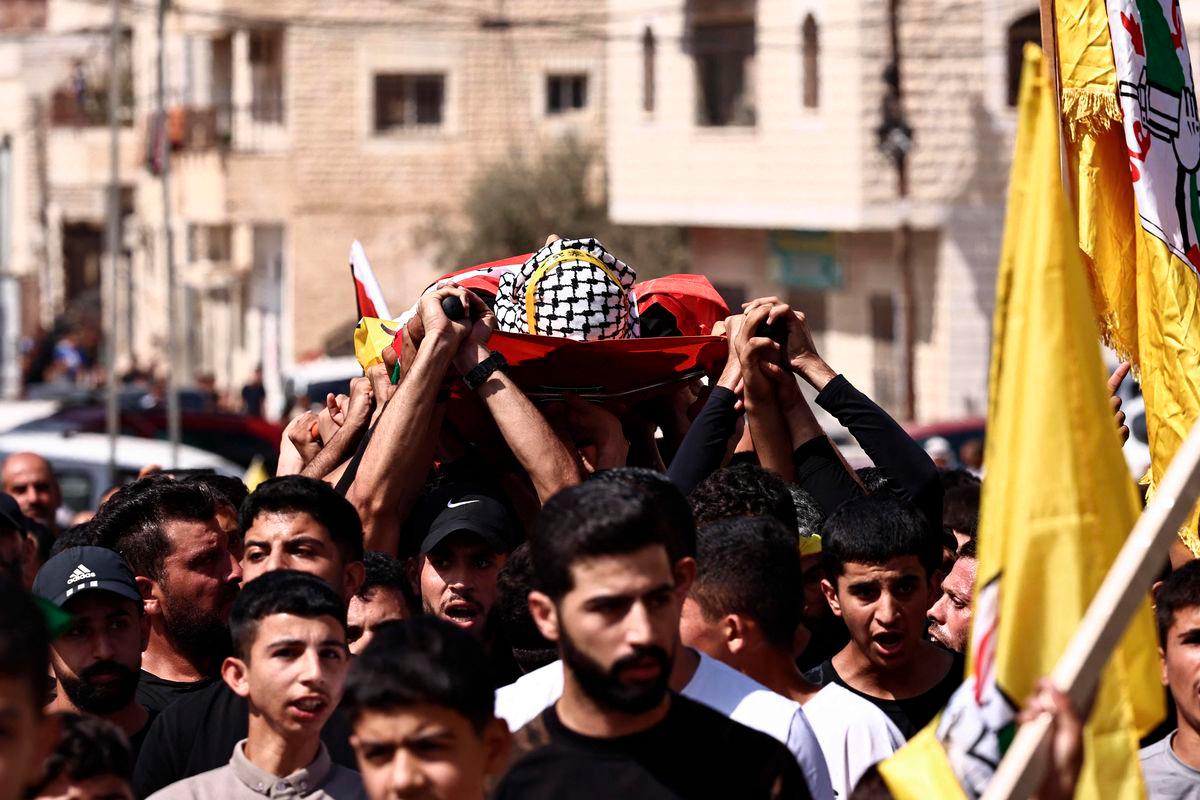 Mourners carry the body of 20-year-old Said Al-Naasan, who was killed during clashes with Israeli settlers the previous day, during his funeral in the occupied West Bank village of Al-Mughayyir, north of Ramallah on September 24, 2025. (Photo by Zain JAAFAR / AFP)