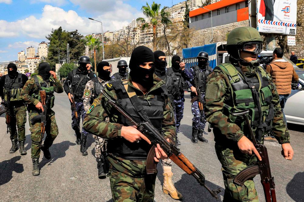 Palestinian security forces patrol along a street during the funeral of Abdel Fatah Hussein Khroushah, a 49-year-old Palestinian who was killed the previous day and was accused of killing two Israeli settlers in the Palestinian town of Huwara on February 26, in Nablus in the occupied West Bank on March 8, 2023. AFPPIX