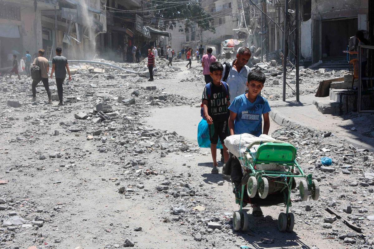 Palestinians search for items to salvage in the rubble of buildings destroyed a day earlier in Israeli strikes on Al-Daraj neighbourhood in Gaza City on July 16, 2025. (Photo by Omar AL-QATTAA / AFP)