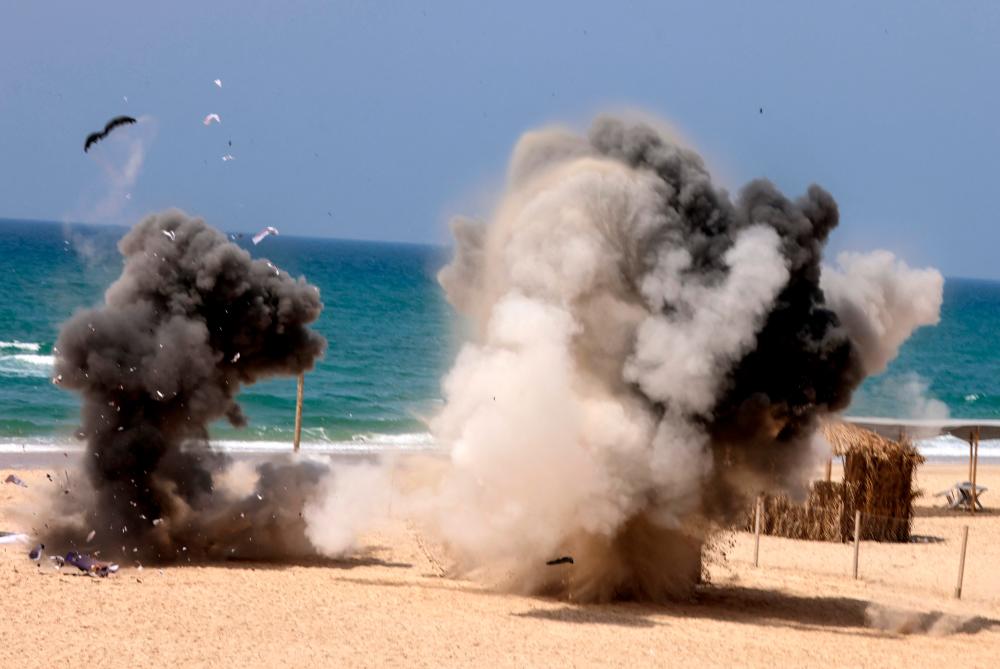 Smoke rises from explosions during a military drill by members of the Mujahideen Brigades, the armed wing of the Palestinian movement of the same name, along the beach in Gaza City, on April 24, 2021. - AFP