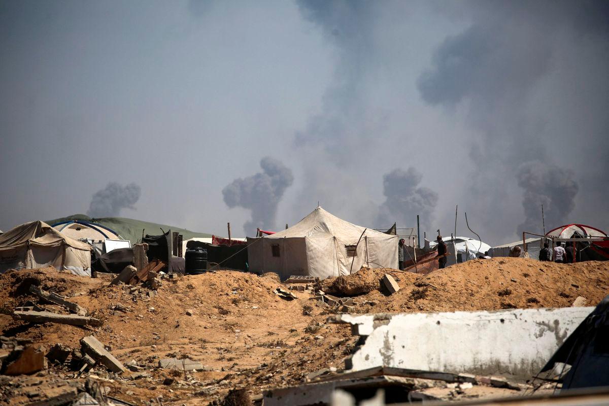 Tents of displaced Palestinians stand in the Nuseirat refugee camp in the central Gaza Strip, as plumes of smoke rise during Israeli bombardment above Gaza City, on September 19, 2025. (Photo by Eyad BABA / AFP)