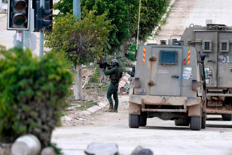 An Israeli soldier takes aim at the entrance of the occupied West Bank refugee camp of Tulkarem, during an ongoing military raid - AFPpix