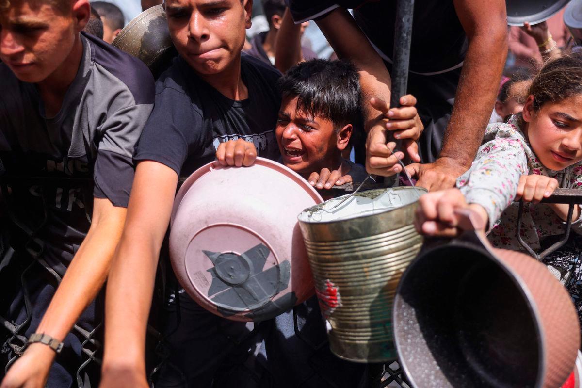 Palestinians shove to get a portion of cooked food from a charity kitchen in Jabalia in the northern Gaza Strip on May 17, 2025. AFPpix