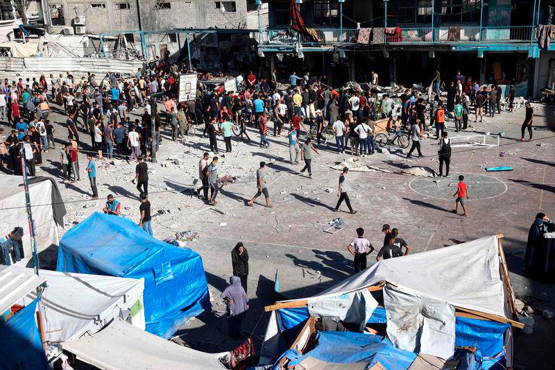 Palestinians stand in the courtyard of a school after an Israeli air strike hit the site, in Nuseirat in the central Gaza Strip - AFPpix