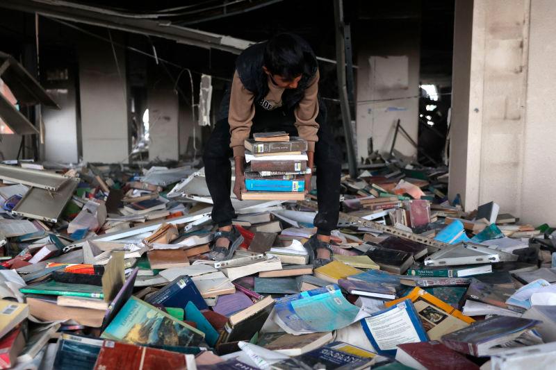 Fore representational purposes-A displaced Palestinian collects books, from the destroyed Islamic University to use as fuel to cook food, in Gaza City on March 21, 2025.AFPpix