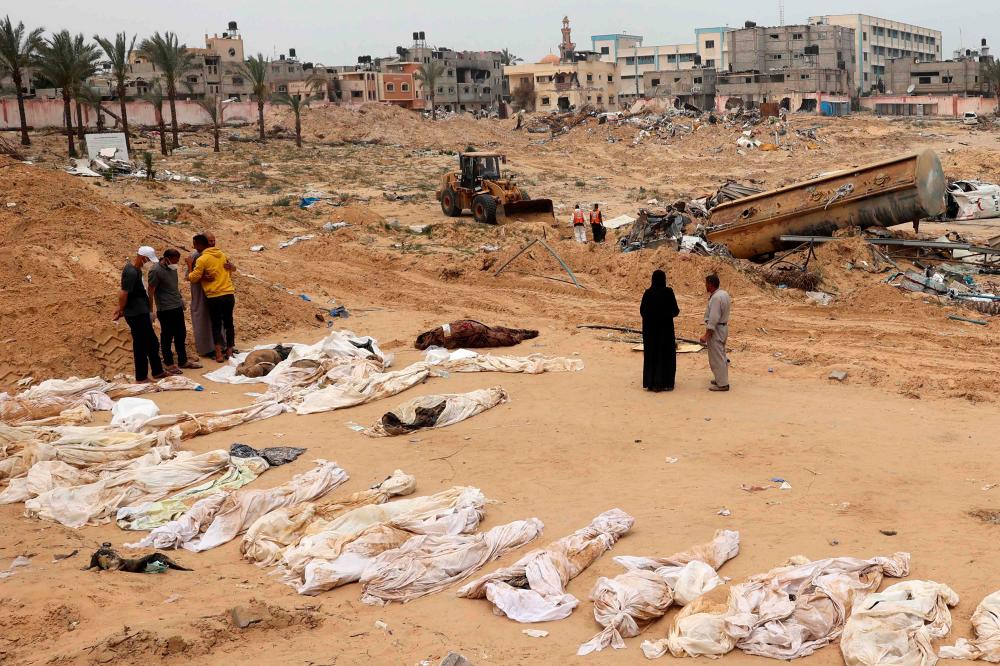 People gather near bodies lined up for identification after they were unearthed from a mass grave found in the Nasser Medical Complex in the southern Gaza Strip on April 25, 2024, amid the ongoing conflict between Israel and the Palestinian militant group Hamas/AFPPix