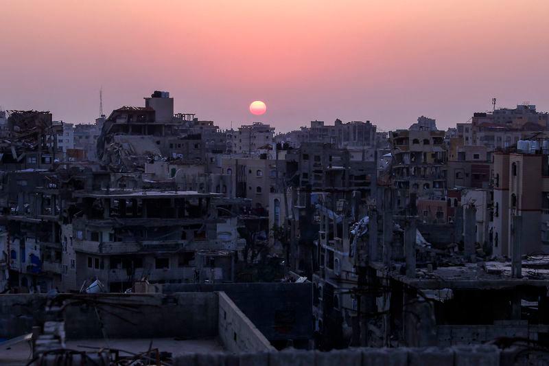 The sun sets behind heavily damaged residential buildings in Jabalia in the northern Gaza Strip - AFPpix