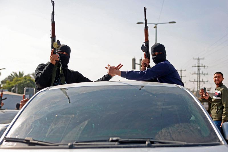 Members of Hamas’s armed wing, the Ezzedine al-Qassam Brigades, take part in a military parade along a street in Deir el-Balah, in the central Gaza Strip on January 19, 2025. The militant group Hamas said on January 19 it was awaiting a list of 90 prisoners to be released by Israel as part of a hostage-prisoner exchange on the first day of the Gaza ceasefire. - BASHAR TALEB / AFP