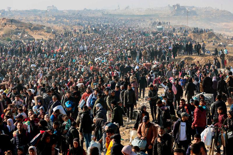 People walk along Gaza’s coastal al-Rashid Street to cross the Netzarim corridor from the southern Gaza Strip into the north - AFPpix