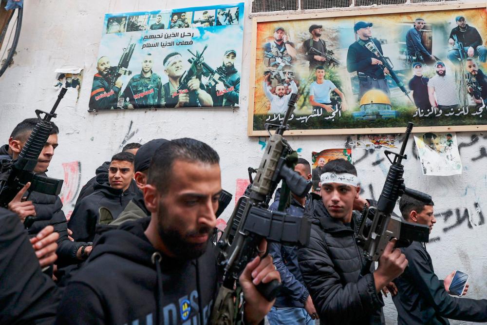 Gunmen from the Al-Aqsa Martyrs Brigades walk in the funeral procession of Montaser Shawa, a 16-year-old Palestinian who died the previous day from his wounds almost two weeks after being shot in the head by Israeli forces in the occupied West Bank, in the Balata refugee camp in Nablus on February 21, 2023. AFPPIX