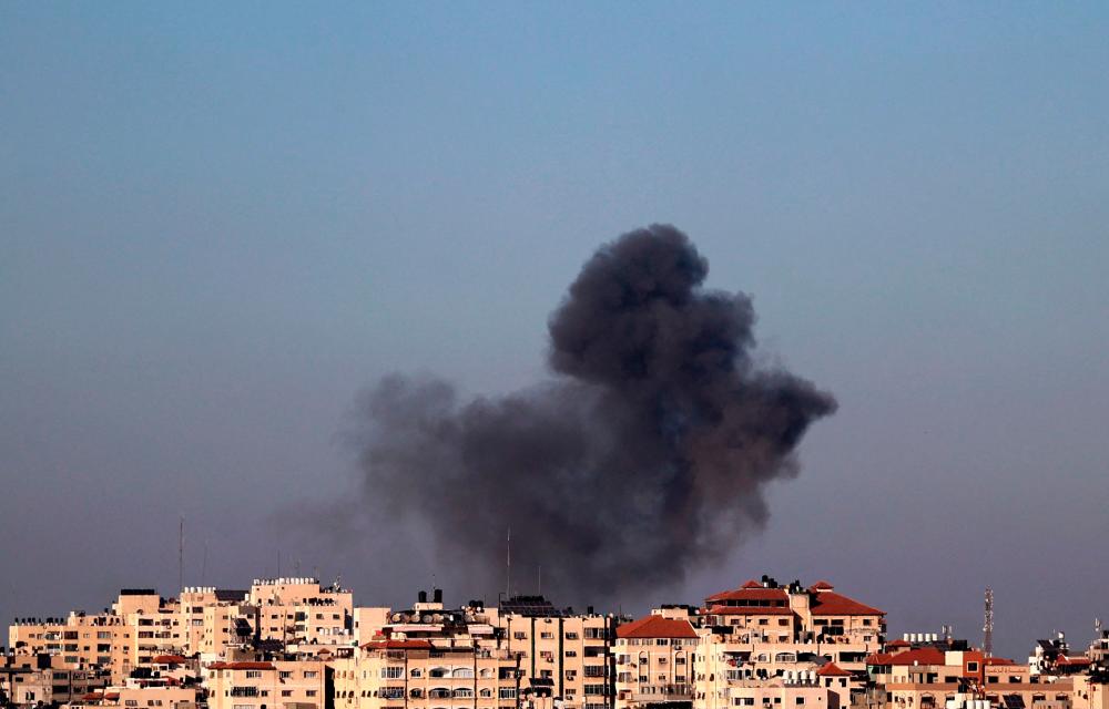 Smoke billows following an Israeli air strike on targets in Gaza City on May 13, 2021. - AFP