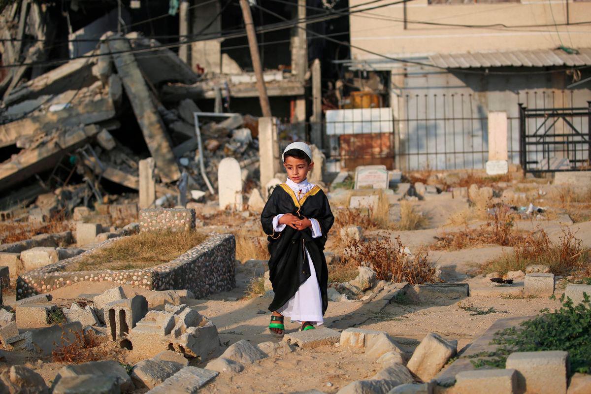 A Palestinian child visits the grave of a loved one on the first day of the Muslim Eid al-Adha festival in Nuseirat, in the central Gaza Strip, on June 6, 2025, amid the ongoing war between Israel and Hamas. - AFPPIX