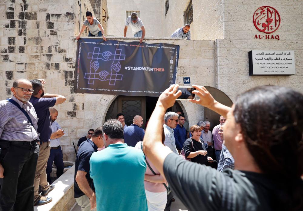 Aktivis menggantung sepanduk di luar Yayasan Al-Haq Palestin di bandar Ramallah Tebing Barat selepas Israel menyerbu dan menutup pejabat mereka, pada 18 Ogos 2022. fotoAFP