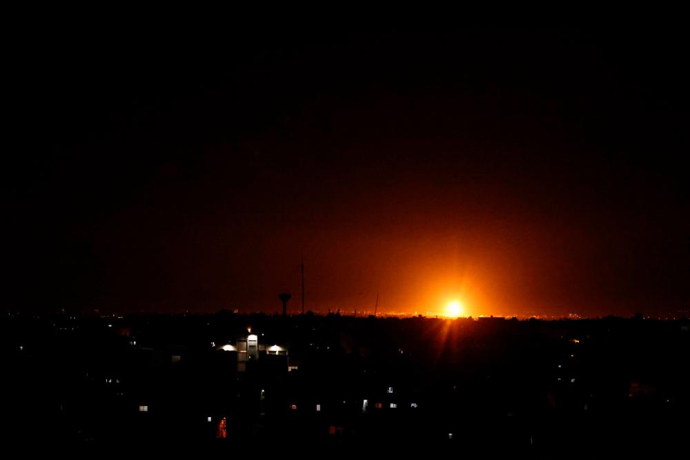 Explosions light-up the night sky at Khan Yunis in the southern Gaza Strip, as Israeli forces shell the Palestinian enclave, early on June 16, 2021. – AFP