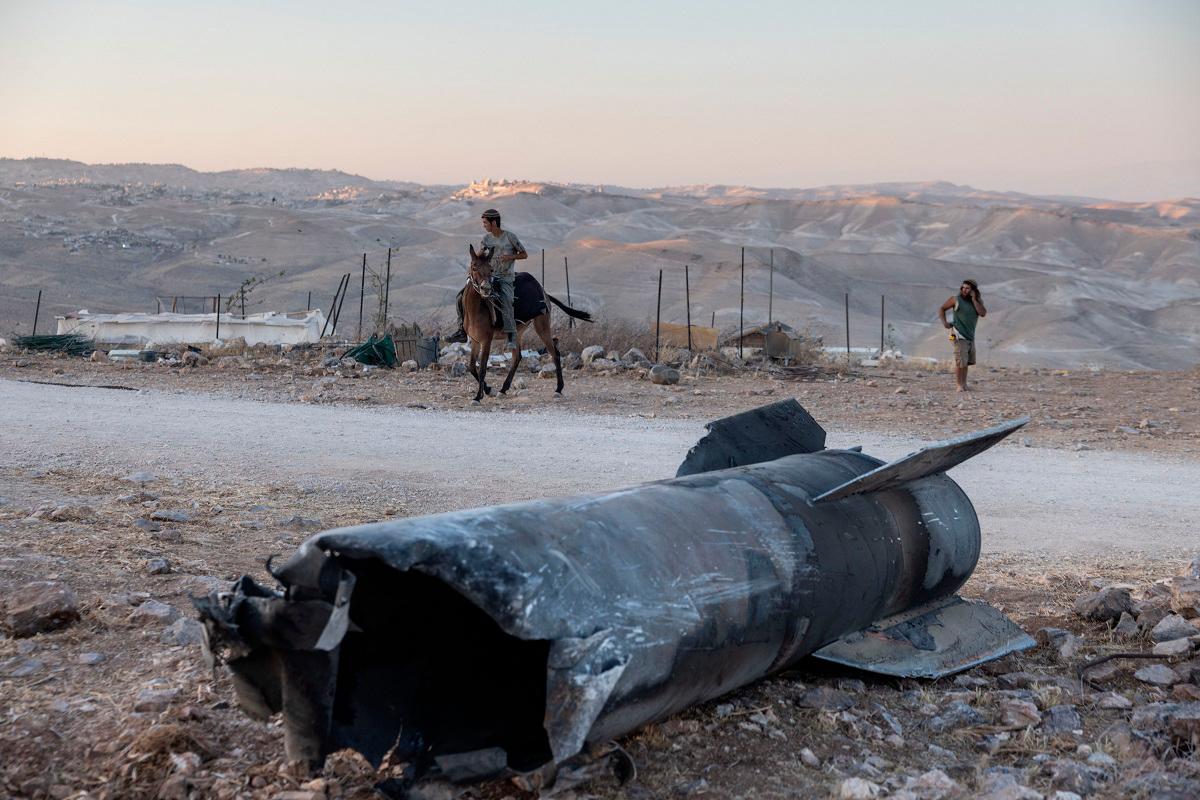 A man rides a horse next to the remains of an Iranian missile that fell an outpost near the Israeli settlement of Tekoa in the occupied West Bank, on 29 June 2025, in the aftermath of the 12-day war between Israel and Iran. - Menahem Kahana / AFP