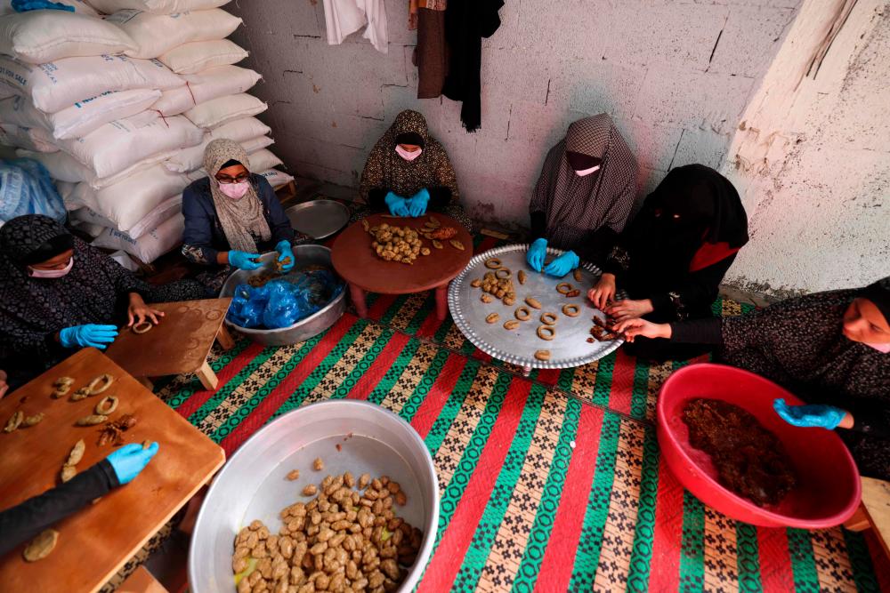 Palestinian Women volunteer in a charity initiative to prepare traditional cookies ahead of Eid al-Fitr, which marks the end of the holy fasting month of Ramadan, in Rafah//AFPix
