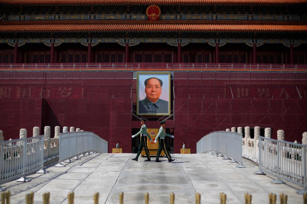 Paramilitary officers change guard in front of the portrait of the late Chinese chairman Mao Zedong in Tiananmen Square in Beijing, China May 7, 2019. - Reuters